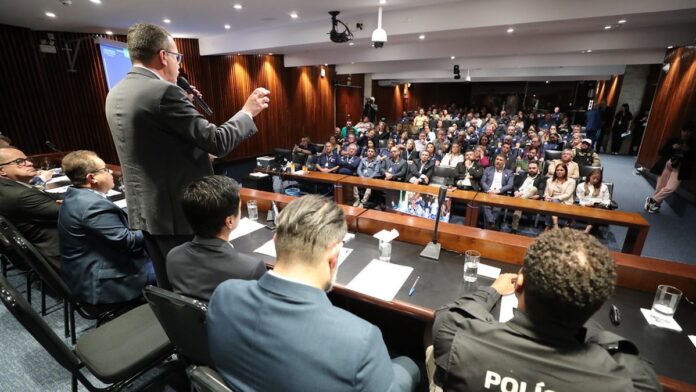 Ilustração digital de um carro estilizado conectado a uma rede de blocos de dados holográficos em tons de azul.