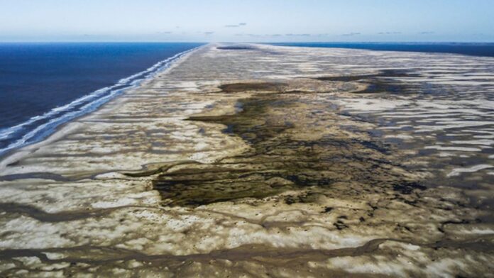 Líderes de diversos países reunidos em uma mesa redonda, com bandeiras nacionais ao fundo, durante cúpula no Rio.