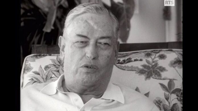 capital-su-o-lucrou-com-repress-o-trabalhista-dura Foto histórica em preto e branco de operários brasileiros em uma linha de montagem industrial sob vigilância.