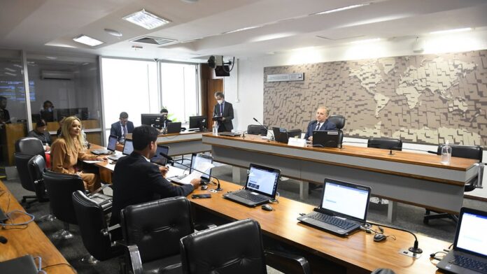 Carreta tecnológica estacionada em praça pública, com jovens interagindo com equipamentos de ciência e robótica.