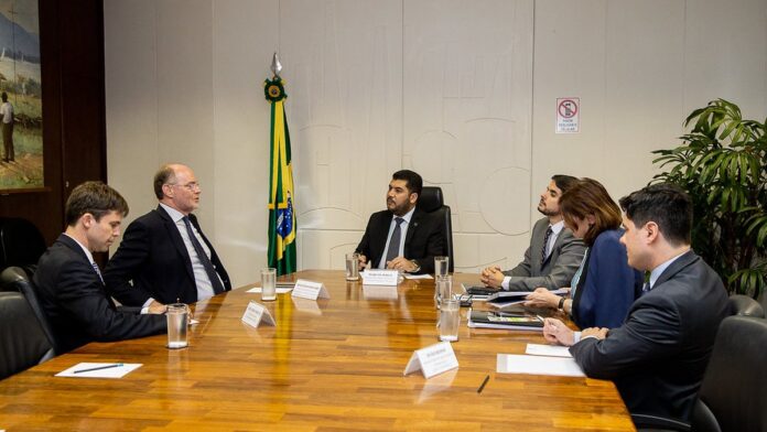 carros-chineses-ter-o-custo-menor-no-brasil-devido Carros elétricos modernos alinhados em uma linha de montagem automatizada com braços robóticos em uma fábrica.