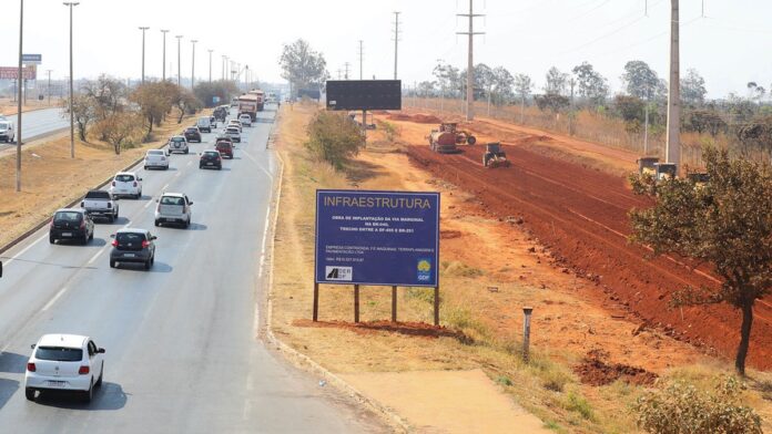 Cena de acidente na rodovia com ônibus danificado e viaturas de resgate isolando a área em Minas Gerais.