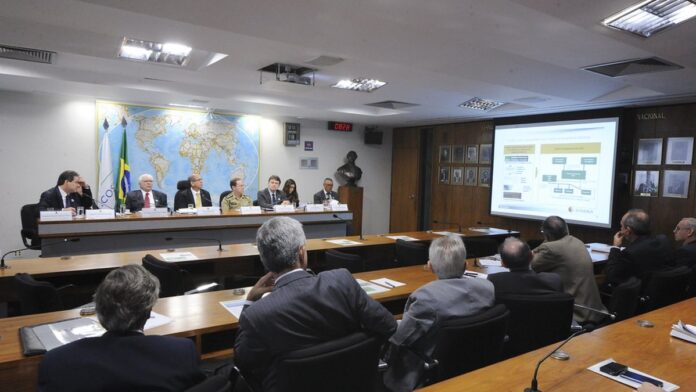 Fernando Diniz gesticula intensamente à beira do campo, vestindo uniforme esportivo durante partida de futebol.