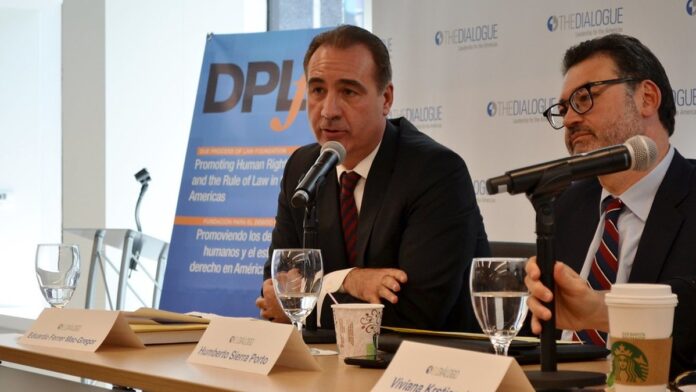 Fachada do tribunal da Corte Interamericana de Direitos Humanos com bandeiras ao vento sob céu nublado.