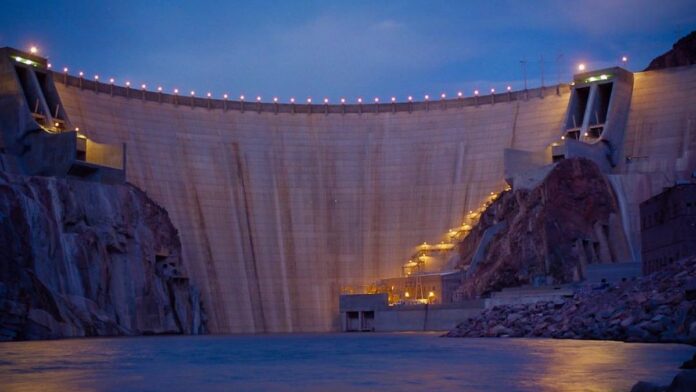 Vista aérea de extensos painéis solares instalados no deserto do Arizona sob um céu claro e ensolarado.