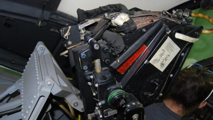 Caça militar sobrevoando uma área oceânica, com equipes de busca em barcos e aeronaves ao longe.