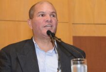 Geovani Silva surpreende torcida do Vasco e ganha homenagem no Espírito Santo Geovani Silva sorri enquanto segura uma placa de homenagem diante de torcedores do Vasco em um estádio.