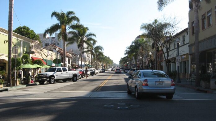 Máquinas pesadas operam em obra de expansão de rodovia com sinalização de tráfego e trecho em asfalto.
