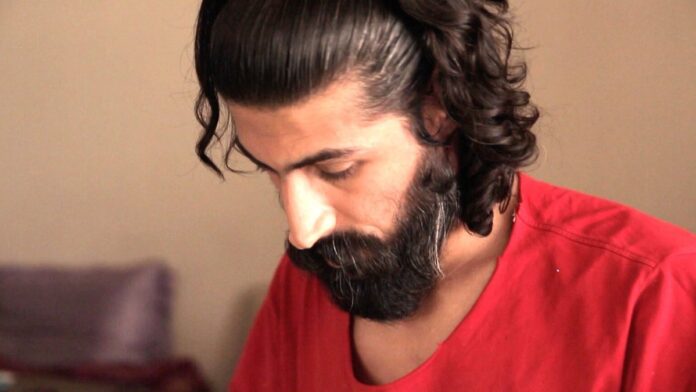 Ruínas de edifícios em uma cidade iraniana sob céu nublado, com fumaça ao fundo e escombros espalhados pelas ruas.