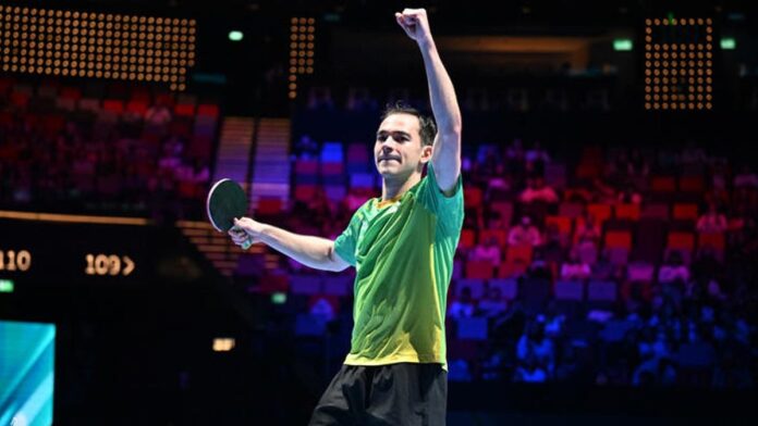 Hugo Calderano comemora vitória em mesa de tênis, levantando o punho e celebrando sua classificação em Macau.