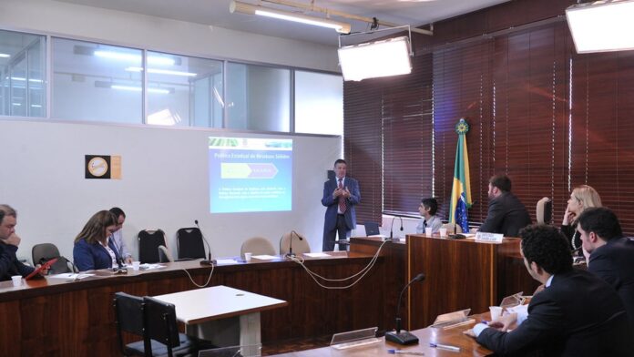 inova-o-no-paran-ganha-pr-mio-internacional-por-au Representantes recebem troféu em palco iluminado durante cerimônia de premiação internacional sobre inovação tecnológica.
