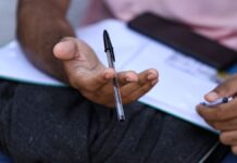 Isenção do Enem 2026: prazo para solicitar o benefício começa no dia 13 Estudante sentado em frente a um computador, com expressão concentrada, preenchendo formulário online do Enem.