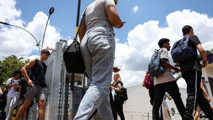 Estudante sentado em frente a um computador, concentrado, com uma página de cadastro do Fies aberta na tela.