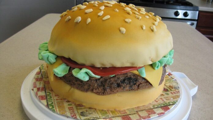 Lobo de pelagem cinzenta caminha por área arborizada com uma coleira de monitoramento GPS no pescoço.