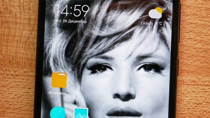 Máquina de lavar branca da Xiaomi com painel digital frontal em ambiente de lavanderia moderno e iluminado.