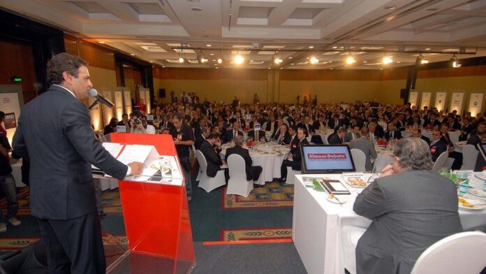 Gráfico financeiro em tons de vermelho mostrando queda acentuada em tela de computador em um escritório.