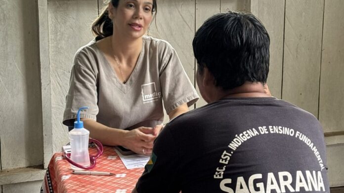 Barco hospitalar atracado em rio na Amazônia, com equipe de saúde atendendo moradores locais em área ribeirinha.