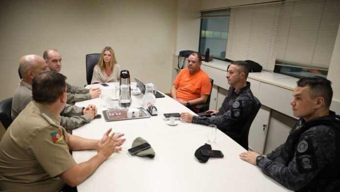 Membros do Ministério Público e autoridades em reunião de planejamento de segurança para partida de futebol.
