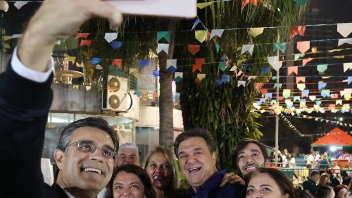 Jogadores do Palmeiras comemoram gol em campo durante partida de futebol com uniforme verde e branco.