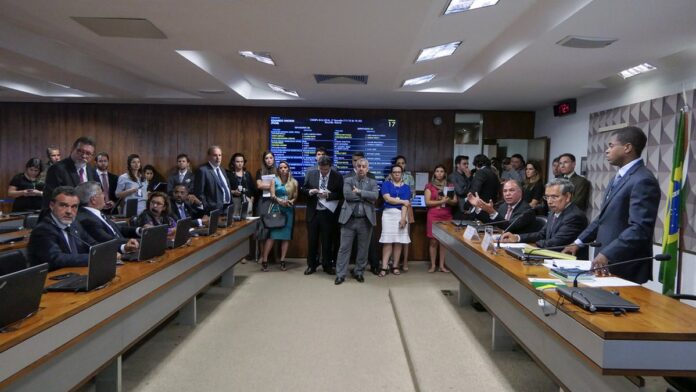 Atacante Bebeto Almeida, vestindo uniforme de futebol, sorrindo e gesticulando em campo durante treino.