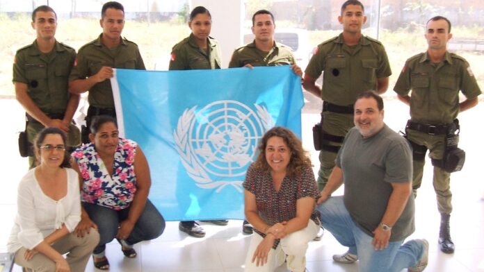 Pesquisadores recebem troféu do Prêmio Sebrae em cerimônia com banners da instituição ao fundo.