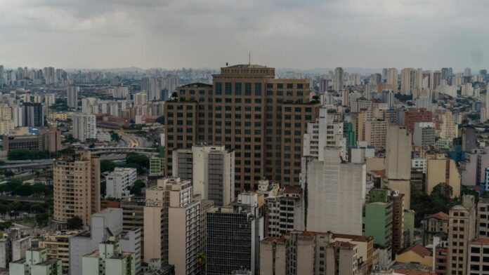 View of São Paulo's skyline featuring modern and historic architecture under cloudy skies.