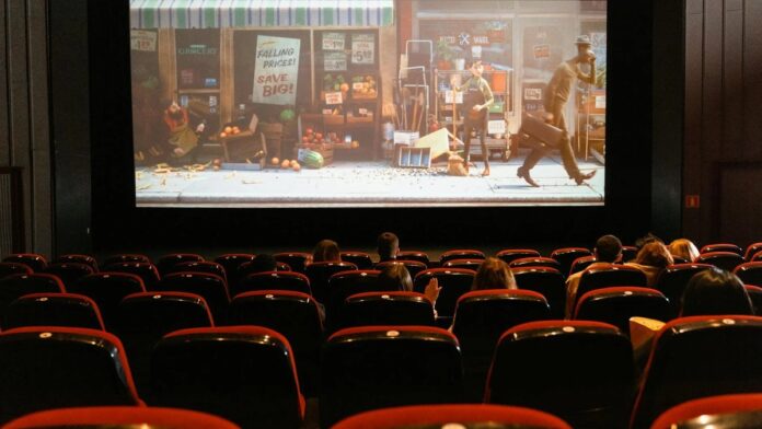 A cozy indoor movie theater showing an animated film to a small audience.