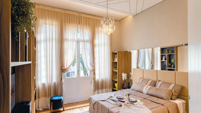 Cozy bedroom with elegant decor, soft lighting, and breakfast spread on bed, perfect for relaxation.