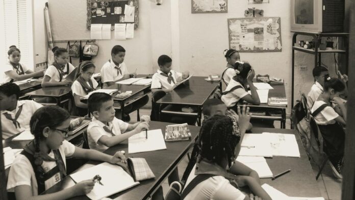 A classroom of attentive school children studying at their desks in uniform.