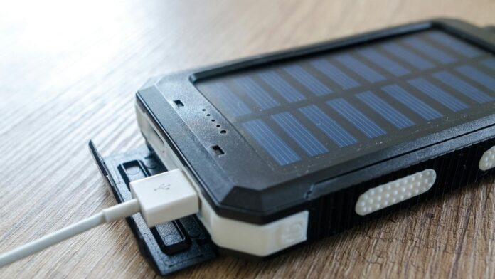 A close-up of a solar charger with a USB connection on a wooden surface, showcasing modern technology.