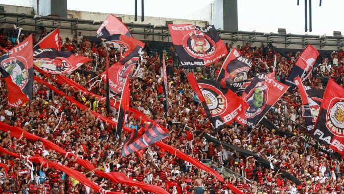 s4-1270d9ccf899-69 A lively crowd of Flamengo supporters waving flags at Maracanã Stadium in Rio de Janeiro.