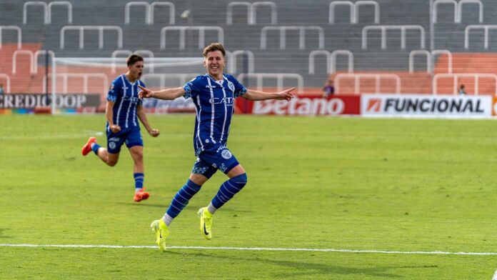 Excited soccer players celebrate a goal on the field during a match.