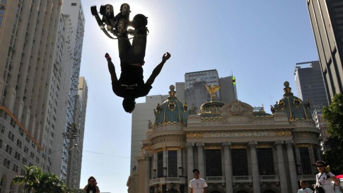 Stunning silhouette of a street performer jumping in front of Theatro Municipal in Rio de Janeiro.