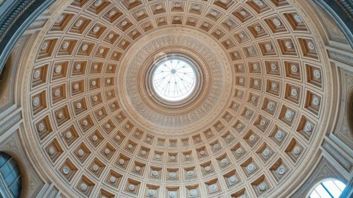 Intricate dome ceiling with skylight in the Vatican City, showcasing architectural brilliance.