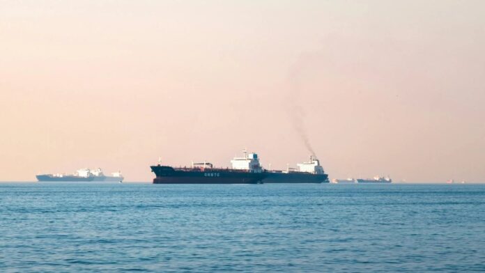 Large industrial tanker ships navigating the open sea under a clear sky, illustrating maritime transportation.