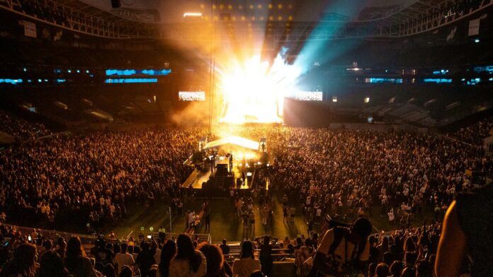 Lively concert atmosphere captures the energy of a packed crowd in a São Paulo stadium at night.
