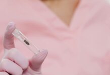 Implante hormonal no SUS: Ministério da Saúde qualifica 11 mil profissionais Close-up of a nurse holding a dental implant in a sterile environment.