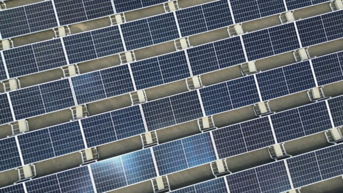 Array of solar panels in grid layout viewed from above promoting renewable energy