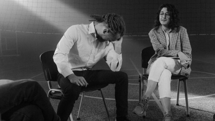 A therapy session with people discussing mental health in a supportive environment.