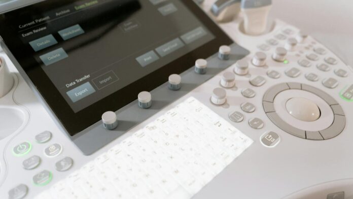 s4-3aaa020f55d0 Detailed view of a medical ultrasound machine control panel with buttons and screen.