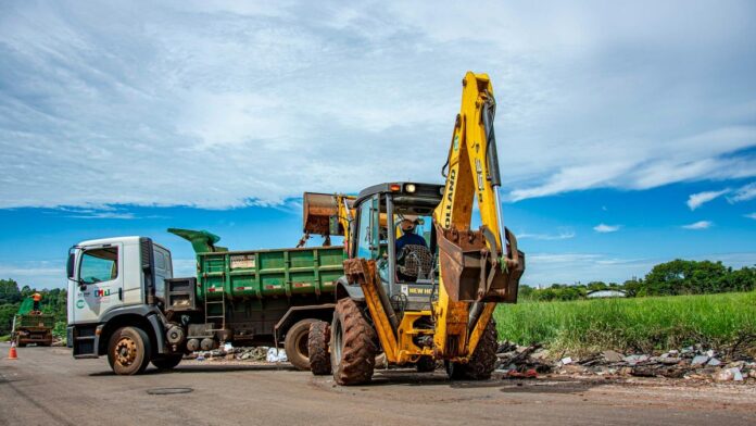Excavator and truck clearing rubble in Londrina, Brazil outdoors.