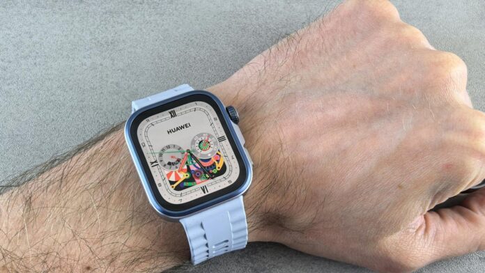A detailed view of a Huawei smartwatch with a colorful display, worn on a human wrist.