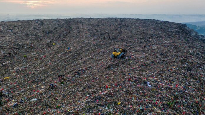 A sprawling aerial view of a landfill in West Java, Indonesia, showcasing environmental impact.