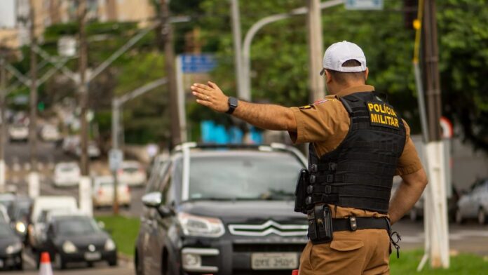 Police officer directing traffic on a busy street in Londrina, Brazil.
