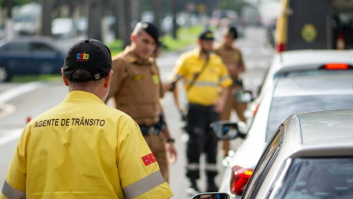 Traffic agent in bright uniform managing vehicles on a busy Londrina street.