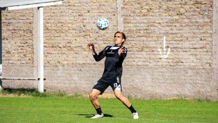 Dynamic shot of a football player preparing to control the ball during training.
