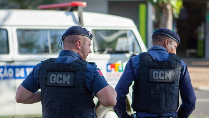 Two municipal guards in uniform patrolling the streets of Londrina, Brazil.