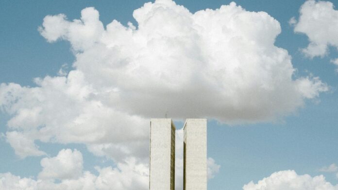 View of the National Congress in Brasília with impressive cloud formations in the sky.