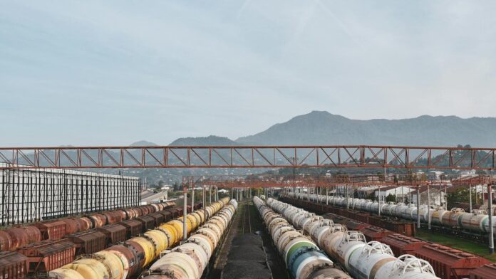 Aerial view of cargo trains lined up at a large railway yard under a blue sky.