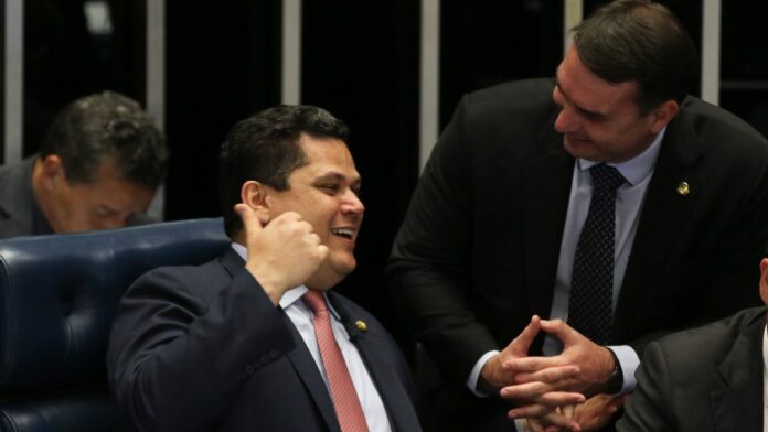 O presidente do Senado, Davi Alcolumbre e o senador Flávio Bolsonaro, conversam no plenário do Senado durante sessão que apro